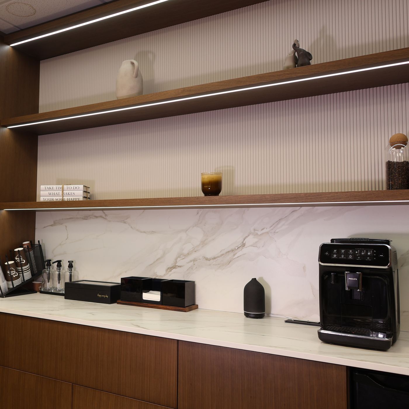 Walnut cabinetry with marble backsplash and floating shelves by Mastery Cabinetry