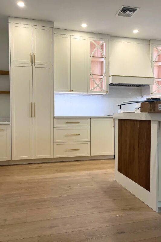 Cream kitchen cabinetry with wood accents by Mastery Cabinetry