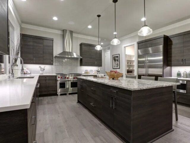 Dark grey kitchen with large island and pendant lighting