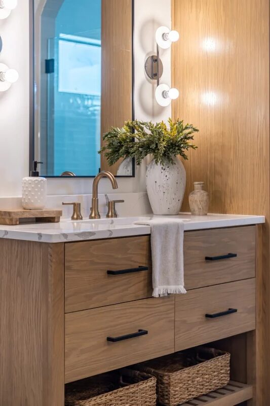 Oak bathroom vanity with open basket storage by Mastery Cabinetry