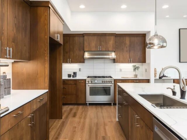 Walnut kitchen cabinetry with range and stone worktop