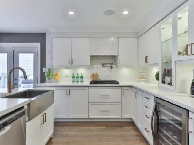 White kitchen cabinetry with wine fridge and farmhouse sink
